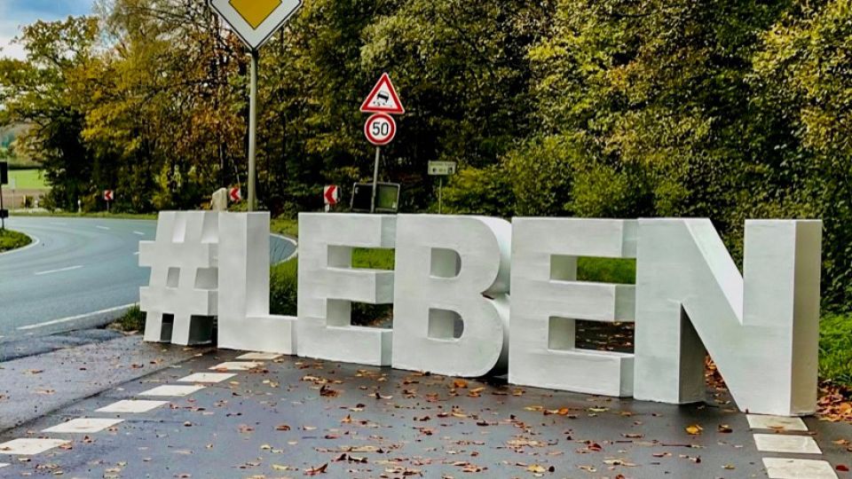 Die Buchstaben LEBEN stehen auf einer Straße